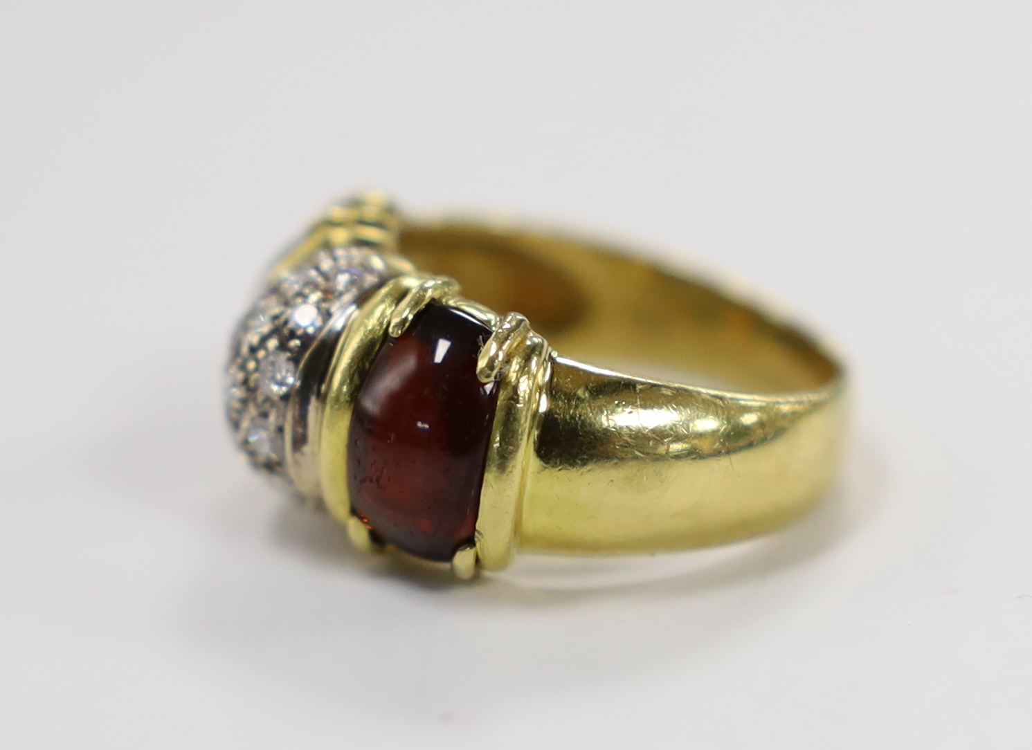 A modern 750 yellow metal and diamond cluster set dress ring, with two stone cabochon garnet set shoulders, size Q, gross weight 9.7 grams.